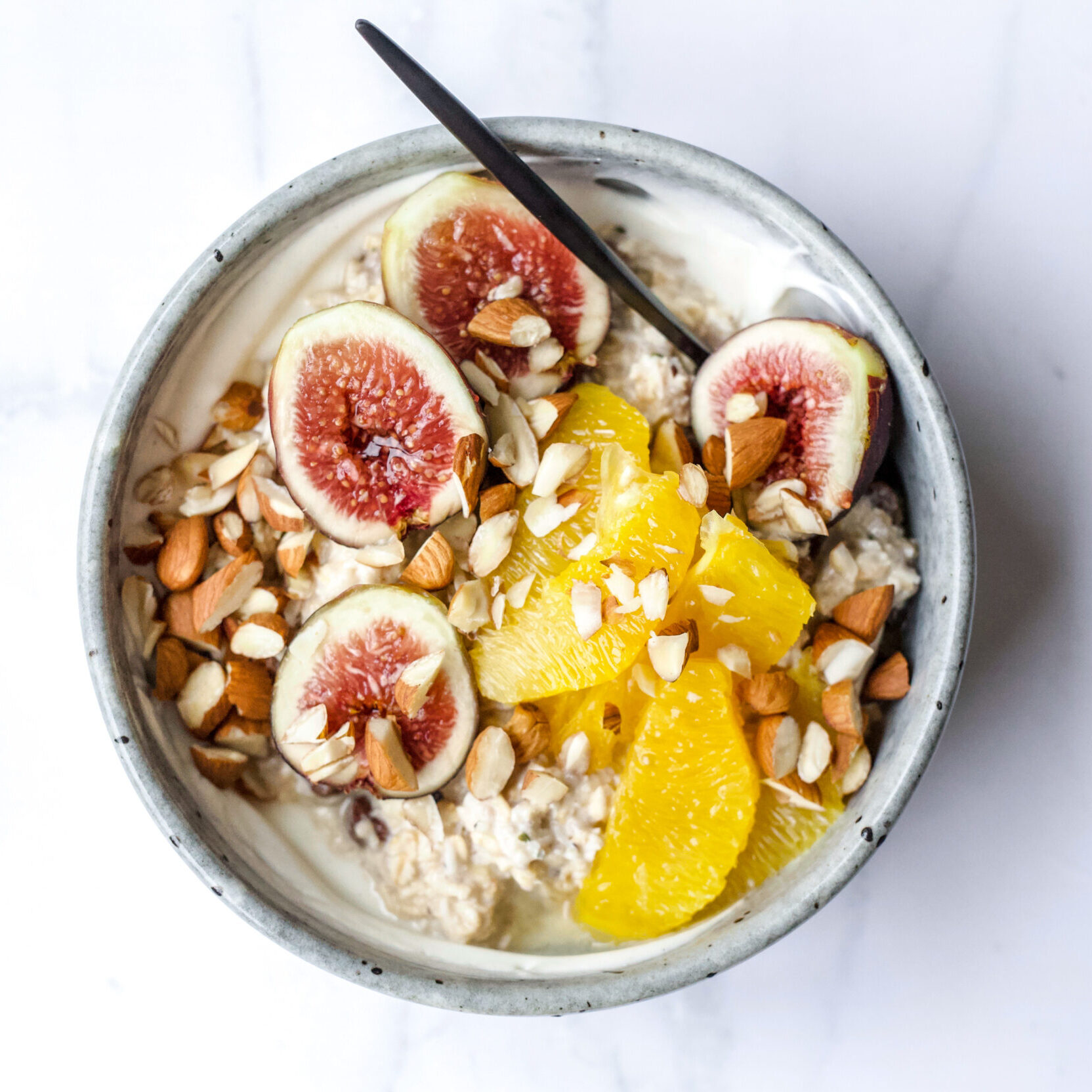 Jacqueline Alwill Fig and orange overnight oats breakfast bowl on marble benchtop