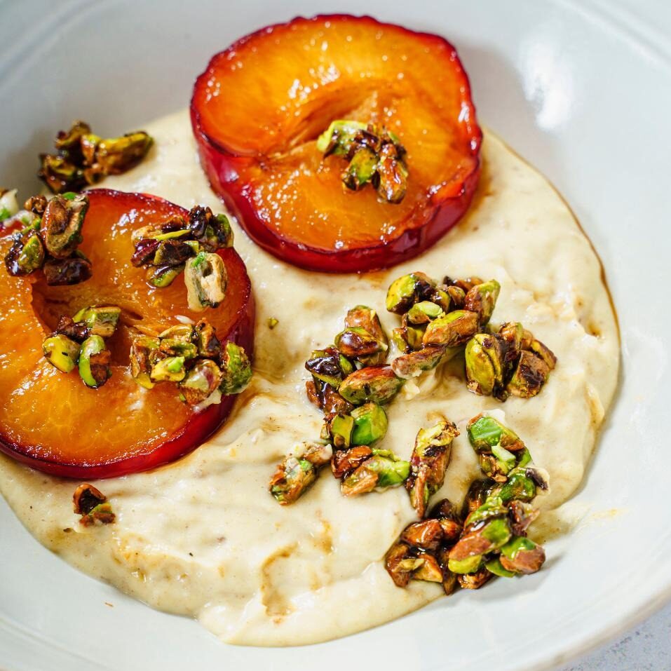 Mousse in bowl topped with grilled prunes and caramelised pistachios