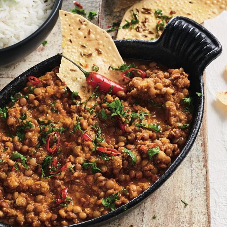 Dhal makhani by Tammy Fry in oval serving dish with rice and papadums