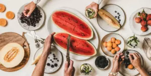 Sharing fruit with friends - watermelon and other tropic fruits on table