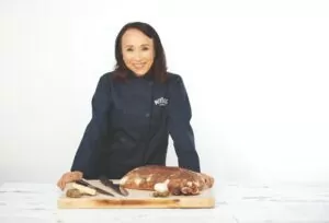 Miyoko in navy chef's jacket with cheeseboard