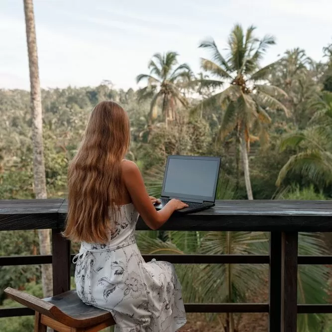 Next-level-courses-feature-woman-on-laptop-on-outdoor-deck-overlooking-forest
