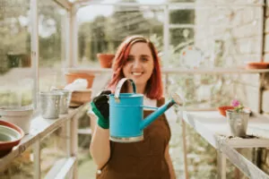 Female,Gardener,With,A,Blue,Watering,Can