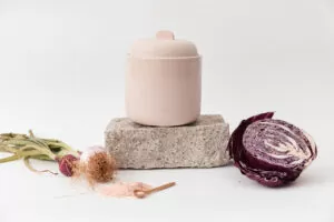 Fermentation pot on stone slab, with sauerkraut ingredients