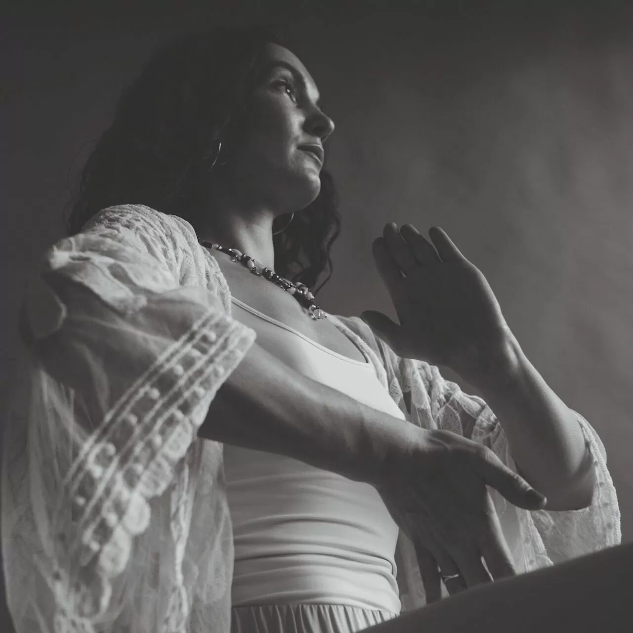 Journey into stillness - black and white photograph depicts woman in seated meditation pose with hands appearing to be in motion