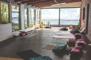 Happy Buddha Retreats meditation space with view over grounds and laid out with yoga mats and cushions