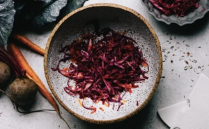 Sauerkraut image - in bowl on table with cabbage, carrots and beetroot. Recipe by Aysha Monticone. Photography by Samantha Woods