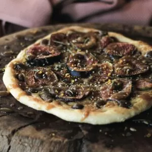 Sweet fig pizza with salted caramel and chocolate on wooden board