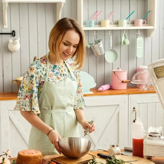 Young woman preparing a cake in the kitchen - vegan gluten free baking by Sara Kidd for Nourish magazine