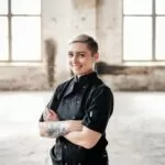 Tenille Evans in chef's suit; pictured in warehouse with floor-to-ceiling windows
