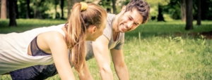 Image depicts woman and man enjoying exercise in the park - healthy plant-based lifestyle concept